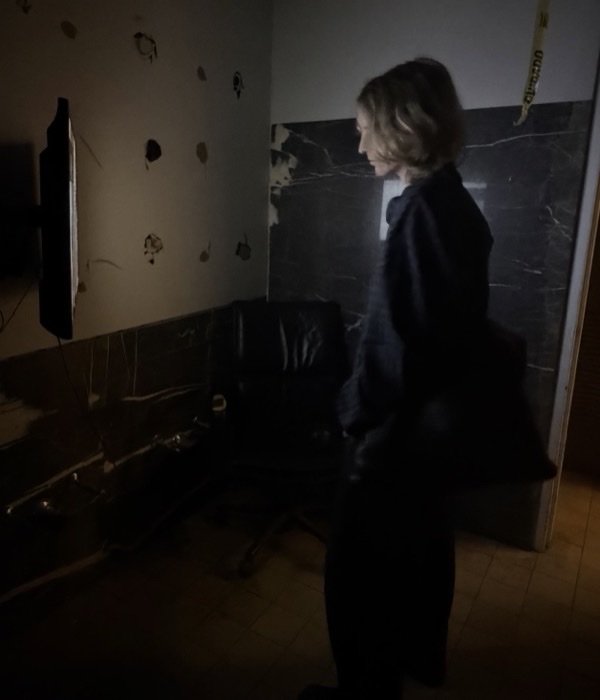 kathleen in a dark room, lit by a glowing monitor